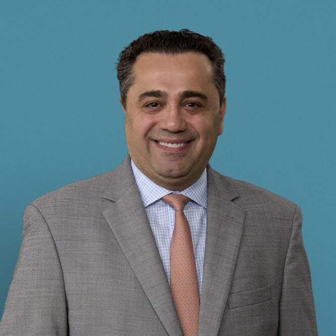 Professional headshot of Dimitrios Topalidis, MD in gray suit and orange tie