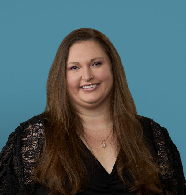 Professional headshot of Elissa Reed, APRN-CNP, smiling in black lace top