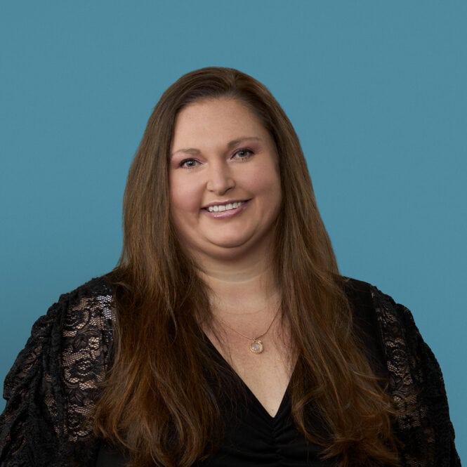 Professional headshot of Elissa Reed, APRN-CNP, smiling in black lace top