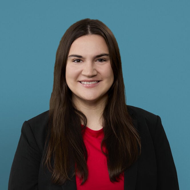 Professional headshot of Emma Boyd, PA-C, smiling in business attire against blue background