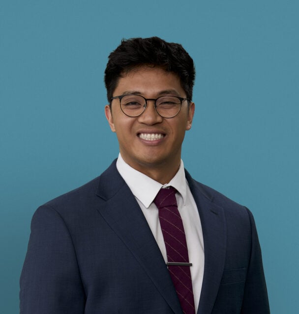 Professional headshot of Erick Nazareno, PA-C in navy suit with burgundy tie