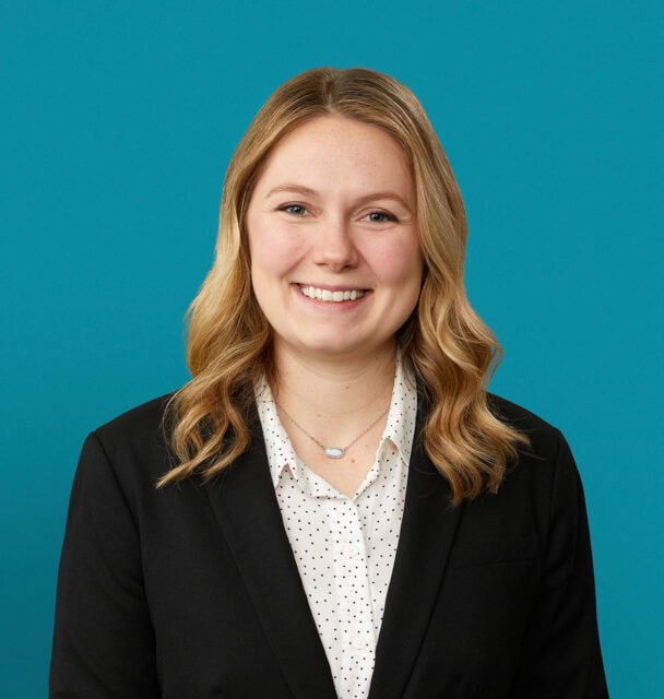 Professional headshot of Erin Cavanaugh, PA-C wearing black blazer against teal background