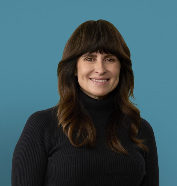 Professional headshot of Evelyn Robbins, APRN-CNP, smiling in black turtleneck sweater