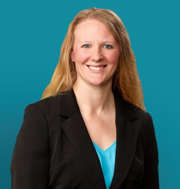 Professional headshot of Dr. Gretchen L. Polinski in black blazer against teal background