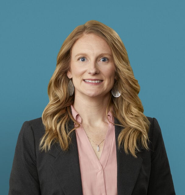 Professional headshot of Hayley R. Burnett, APRN-CNP in dark blazer against blue background