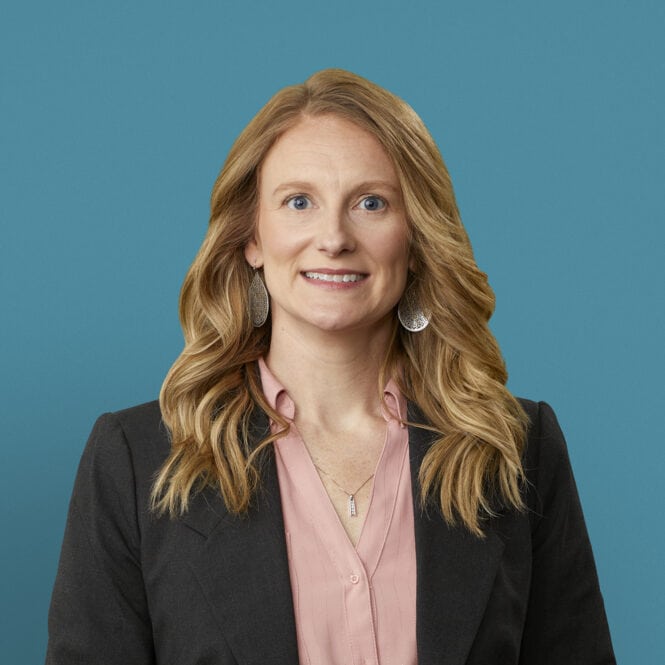 Professional headshot of Hayley R. Burnett, APRN-CNP in dark blazer against blue background