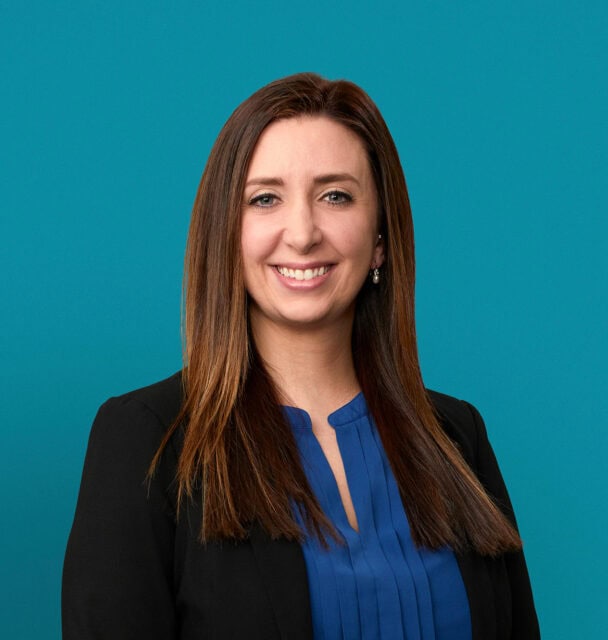 Professional headshot of Hilary Haley, APRN-CNP in black blazer and blue blouse