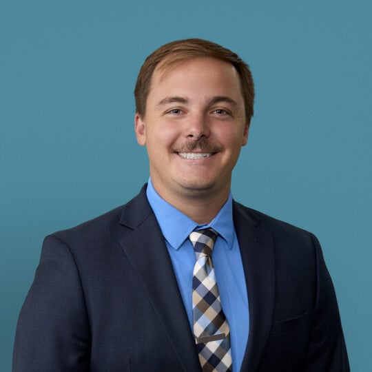 Professional headshot of Jacob Dickman, MD in dark suit and blue shirt smiling