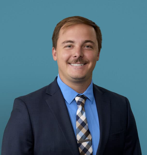Professional headshot of Jacob Dickman, MD in dark suit and blue shirt smiling