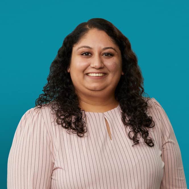Professional headshot of Dr. Jalpa Soni smiling in pink striped blouse against teal background