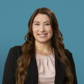 Professional headshot of Jamie J. Drake, APRN-CNP, smiling in business attire against blue background.