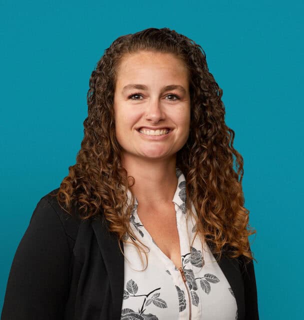 Professional headshot of Jennifer J. Adams, APRN-CNP, smiling in business attire against turquoise background.