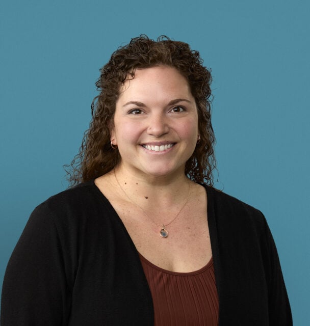 Professional headshot of Jenny Ingle, APRN-CNP, smiling against blue background