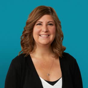 Professional headshot of Jessica Cooper, APRN-CNP, smiling in black cardigan against teal background