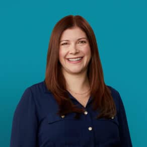 Professional headshot of Jessica L. Karp, DO smiling in navy blue shirt against teal background