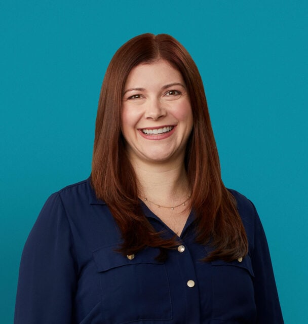 Professional headshot of Jessica L. Karp, DO smiling in navy blue shirt against teal background