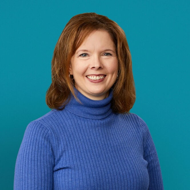 Professional headshot of Jessica Roten, PharmD wearing blue turtleneck sweater against teal background