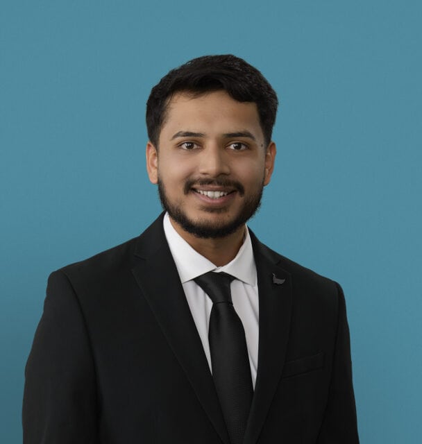 Professional headshot of Jinesh Patel, PA-C in dark suit against blue background