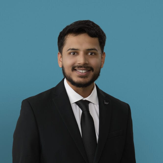 Professional headshot of Jinesh Patel, PA-C in dark suit against blue background