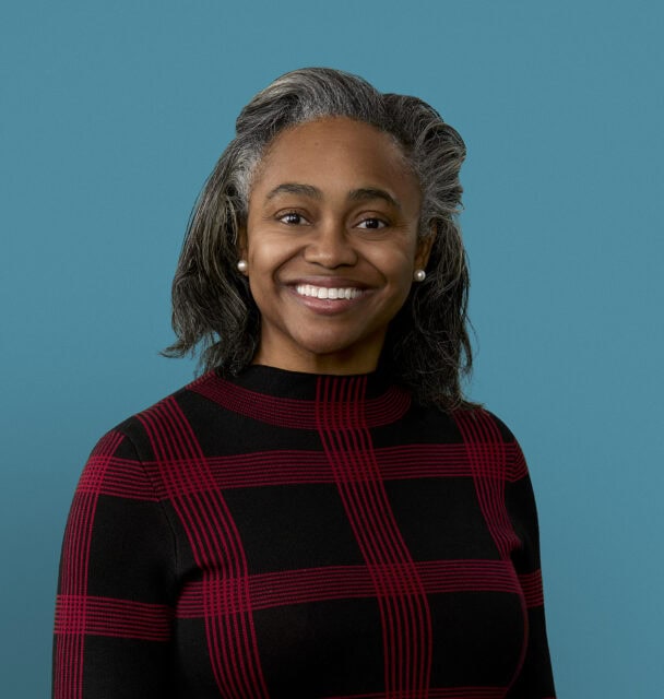 Professional headshot of Dr. Jocelyn Wilson in red and black checkered sweater