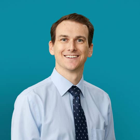 Professional headshot of Dr. Joseph C. King in light blue shirt and tie