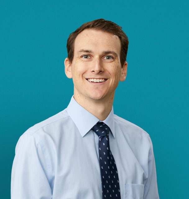 Professional headshot of Dr. Joseph C. King in light blue shirt and tie