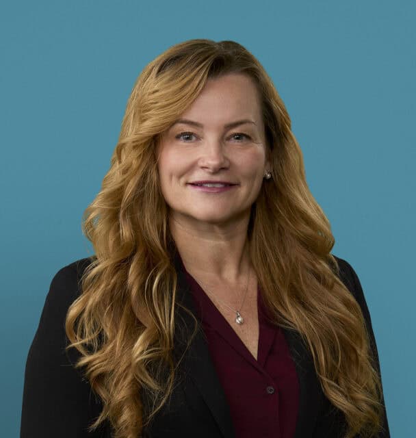 Professional headshot of Julie Hall, APRN-CNP, wearing dark blazer and burgundy blouse