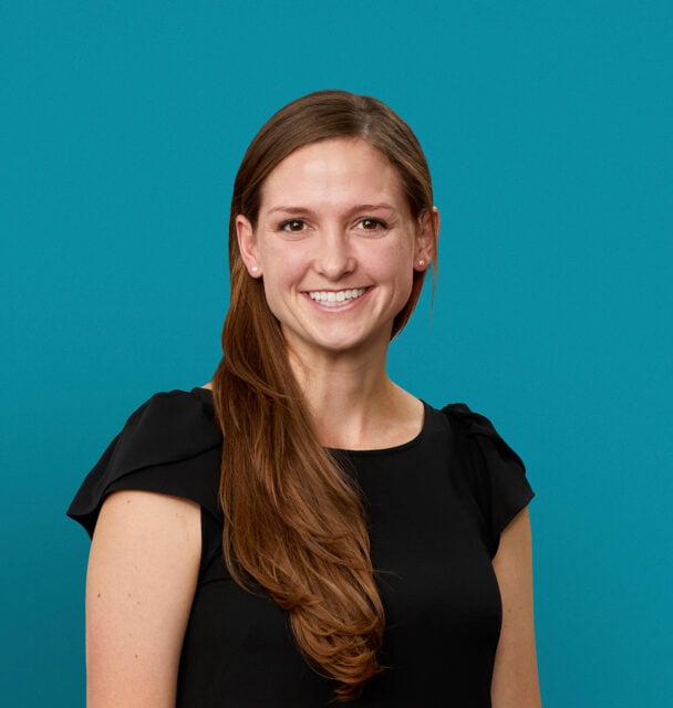 Professional headshot of K. Sarah Derr, PA-C smiling in black top against teal background
