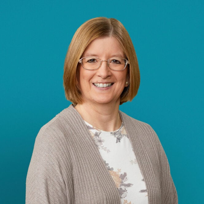 Professional headshot of Dr. Karen E. Starrett smiling against turquoise background