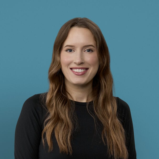 Professional headshot of Katelyn Wilson, APRN-CNP, smiling in black top against blue background