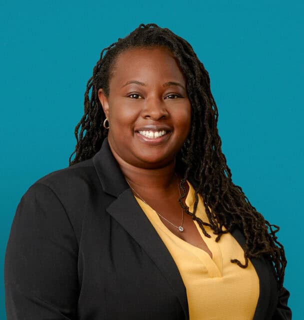 Professional headshot of Katresha J. Williams-Ellington, APRN-CNP, smiling in business attire against teal background