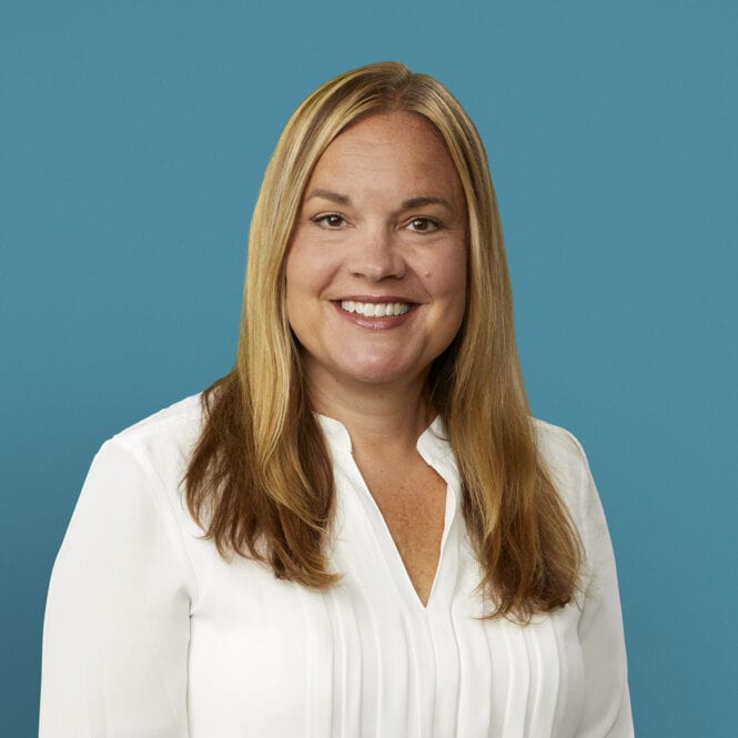 Professional headshot of Katy Boyd, RN, smiling in white blouse against blue background