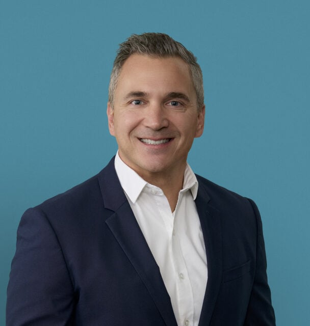 Professional headshot of Dr. Kevin A. Carter in navy suit jacket against blue background