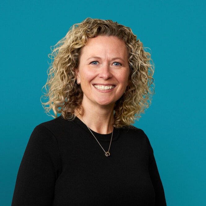 Professional headshot of Kimberly Parker-Maloney, APRN-CNP, smiling in black sweater against blue background