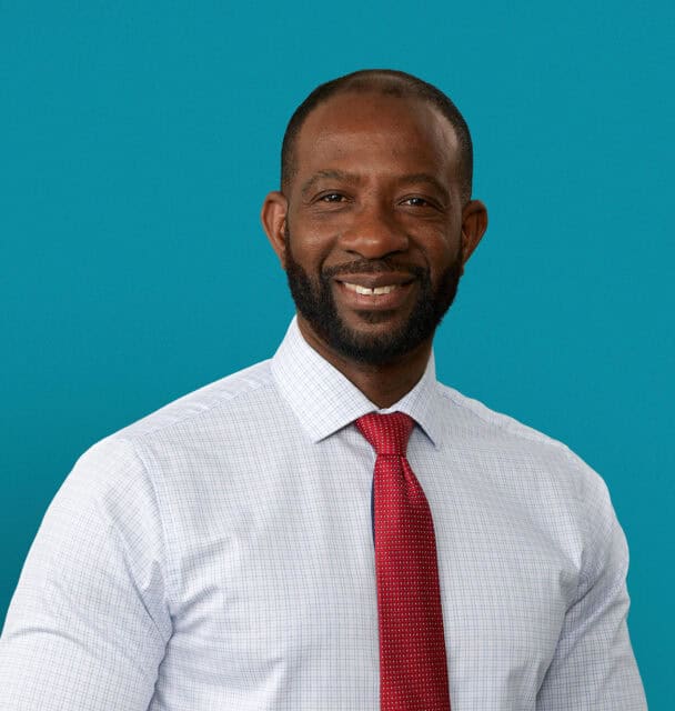 Professional headshot of Dr. Kokou Adompreh-Fia in dress shirt and red tie