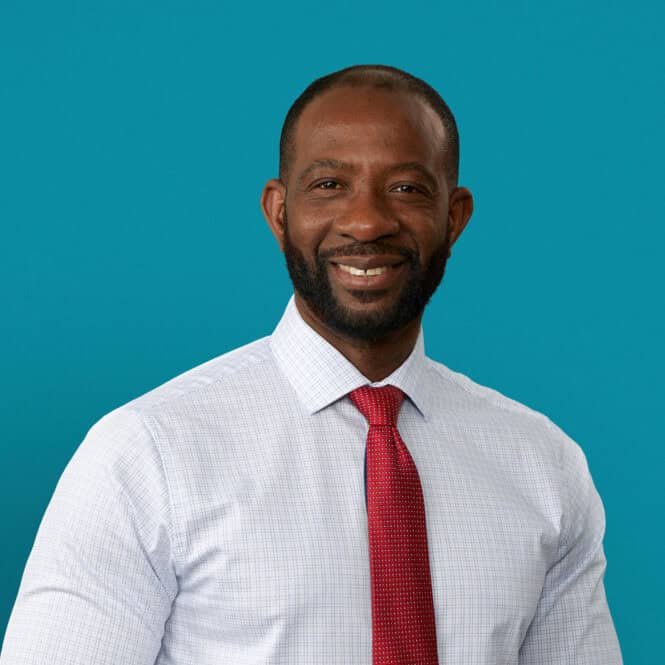 Professional headshot of Dr. Kokou Adompreh-Fia in dress shirt and red tie