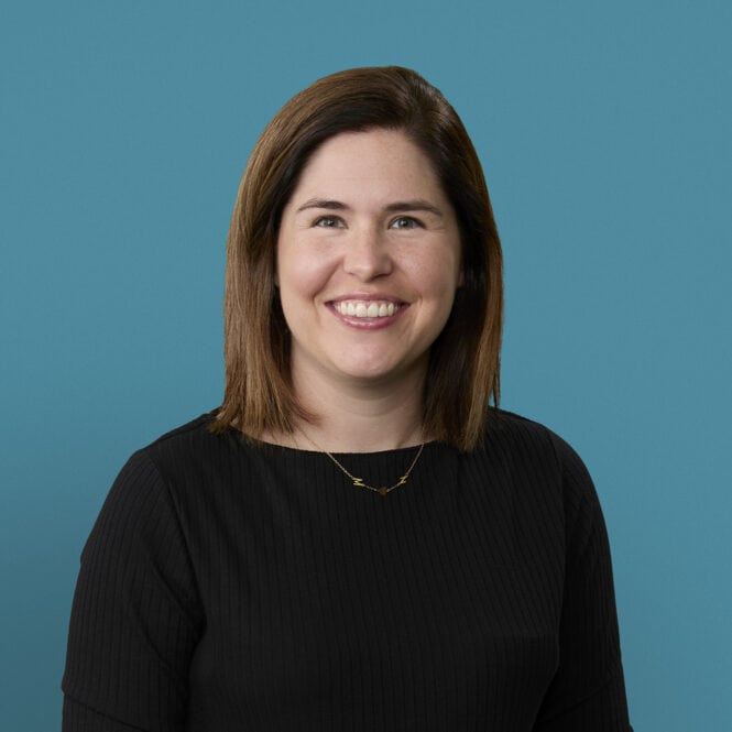 Professional headshot of Kristen Morrison, PA-C, smiling in black sweater against blue background