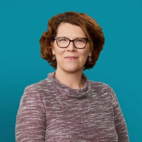 Professional headshot of Laura Knisley, APRN-CNP wearing glasses and marled sweater against teal background