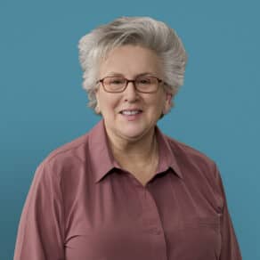Professional headshot of Linda Vaders, APRN-CNP, smiling in maroon shirt with glasses