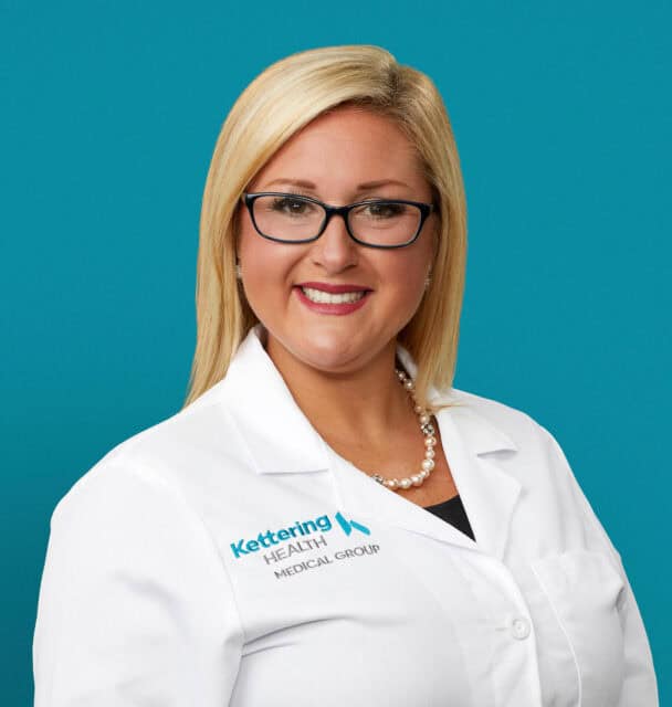 Professional headshot of Lisa N. Lane, nurse practitioner in white coat with pearl necklace