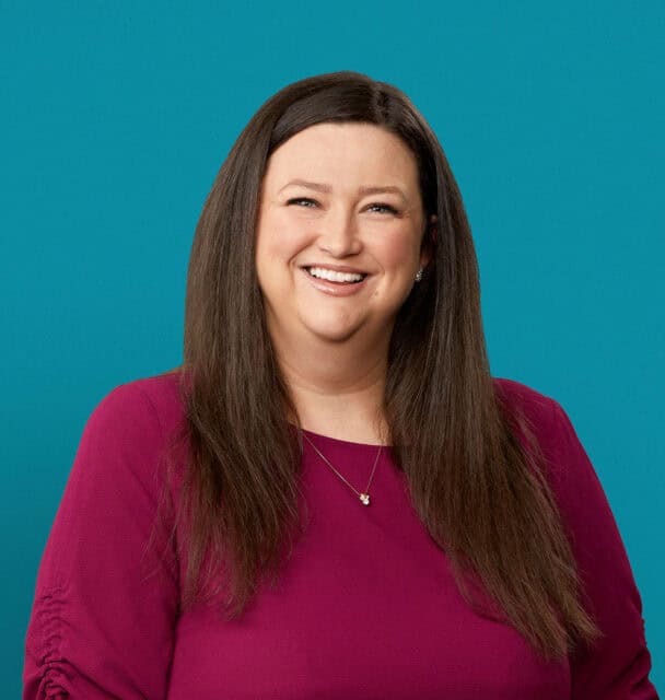Professional headshot of Lori A. Washing, APRN-CNP in maroon top against teal background