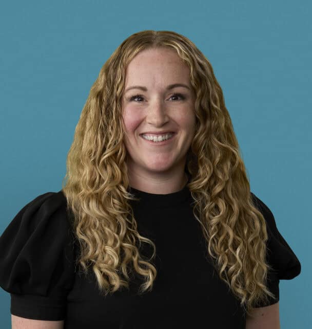 Professional headshot of Mallory Zedella, APRN-CNP, smiling in black top against blue background
