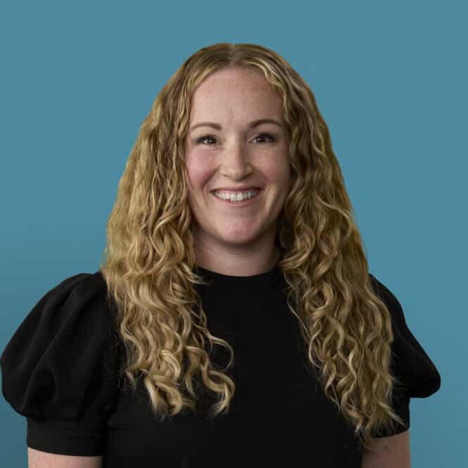 Professional headshot of Mallory Zedella, APRN-CNP, smiling in black top against blue background