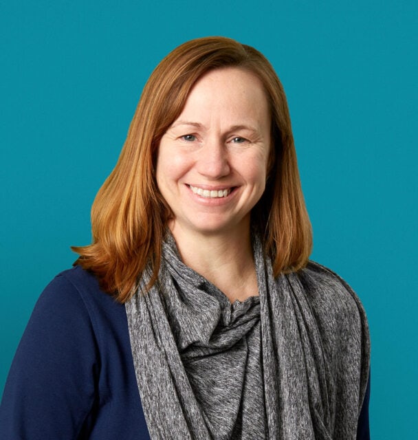 Professional headshot of Marcia R. Williams, APRN-CNP, smiling in navy cardigan against teal background