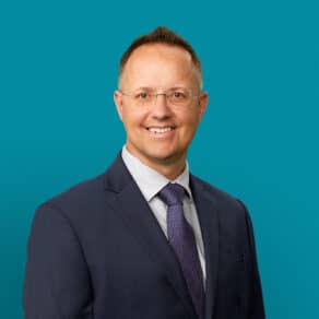 Professional headshot of Marcus P. Bolton, APRN-CNP in business suit against teal background