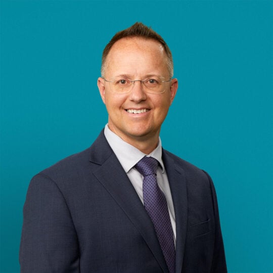 Professional headshot of Marcus P. Bolton, APRN-CNP in business suit against teal background