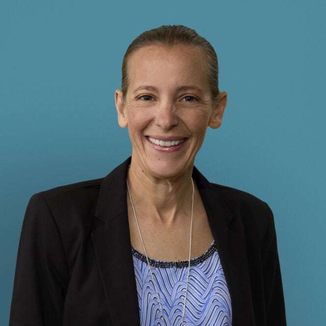 Professional headshot of Mary Fessner, RN, smiling in black blazer against blue background