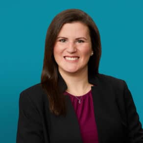 Professional headshot of McKayla Riggs, MD wearing black blazer and purple blouse
