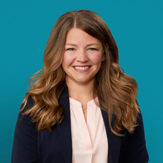 Professional headshot of Megan Kuertz, APRN-CNP, smiling in business attire against teal background.