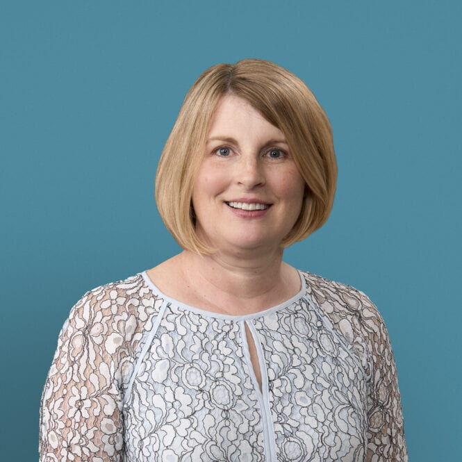Professional headshot of Melissa Cousins, APRN-CNP, smiling in white lace top against teal background.